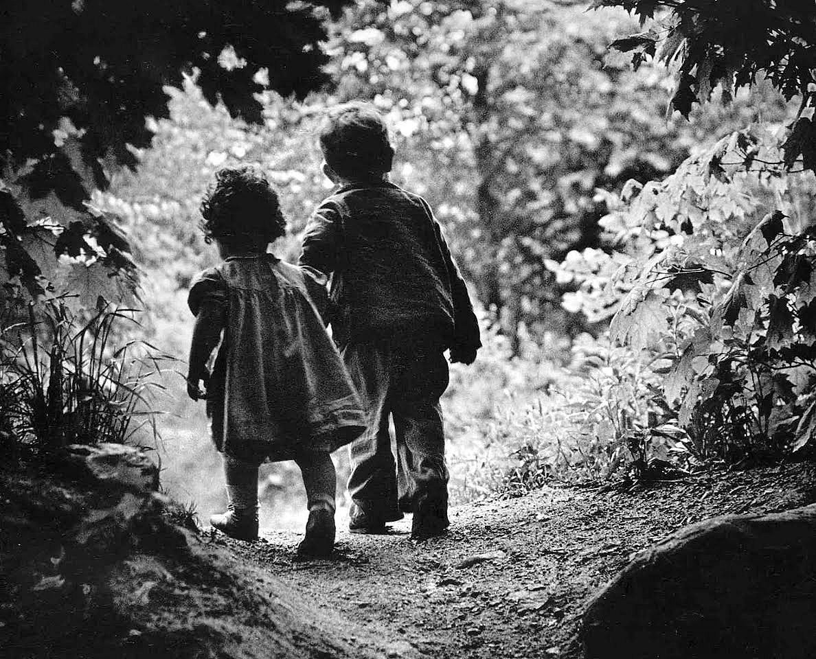 Em 1946, o fotógrafo de guerra norte-americano W. Eugene Smith (1918-1978) passeava na floresta com seus dois filhos, num lindo dia ensolarado. “Enquanto eu seguia os meus filhos, eles avistaram algumas árvores mais altas e ficaram encantados com a descoberta. De repente, Pat agarrou Juanita pela mão e correu. Percebi naquele momento, que apesar de todas as guerras e de tudo o que eu vivi, eu queria cantar um soneto à vida para continuar vivendo aquele momento”, afirmou W. Eugene Smith. Um ano antes, em maio de 1945, em Iwo Jima, Smith sofreu graves ferimentos em uma das mãos e no rosto na explosão de um míssil. Foram necessárias 33 operações para recuperar as suas capacidades. “Quando quis experimentar tirar uma fotografia, até me foi difícil pôr o filme na máquina”, contou Smith. Após dois anos de tratamento, cirurgias plásticas e muitas dúvidas sobre o futuro, Smith voltou ao trabalho ainda mais inspirado em defender seus ideais de “fotografia humanística”.