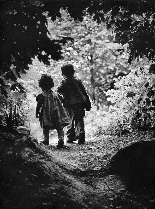 Em 1946, o fotógrafo de guerra norte-americano W. Eugene Smith (1918-1978) passeava na floresta com seus dois filhos, num lindo dia ensolarado. “Enquanto eu seguia os meus filhos, eles avistaram algumas árvores mais altas e ficaram encantados com a descoberta. De repente, Pat agarrou Juanita pela mão e correu. Percebi naquele momento, que apesar de todas as guerras e de tudo o que eu vivi, eu queria cantar um soneto à vida para continuar vivendo aquele momento”, afirmou W. Eugene Smith. Um ano antes, em maio de 1945, em Iwo Jima, Smith sofreu graves ferimentos em uma das mãos e no rosto na explosão de um míssil. Foram necessárias 33 operações para recuperar as suas capacidades. “Quando quis experimentar tirar uma fotografia, até me foi difícil pôr o filme na máquina”, contou Smith. Após dois anos de tratamento, cirurgias plásticas e muitas dúvidas sobre o futuro, Smith voltou ao trabalho ainda mais inspirado em defender seus ideais de “fotografia humanística”.