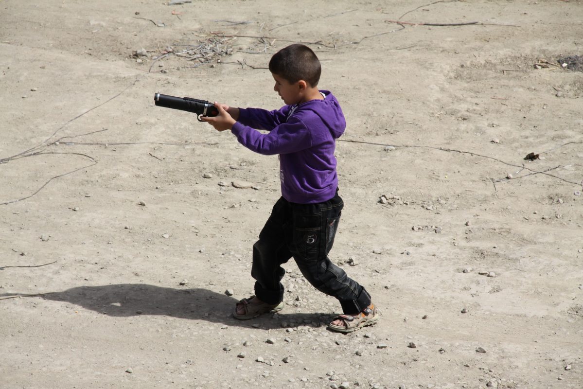 Jovem brinca com um arma de brinquedo no Afeganistão. Acabar com a banalização da violência é dos grandes desafios dos Objetivos do Desenvolvimento Sustentável (ODS) / Lauras Eye