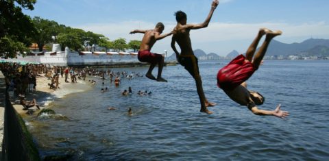 Jovens mergulham na poluída praia do Gragoatá, em Niterói. Doenças de veiculação hídrica provocam atraso escolar de dois anos. Foto Custódio Coimbra