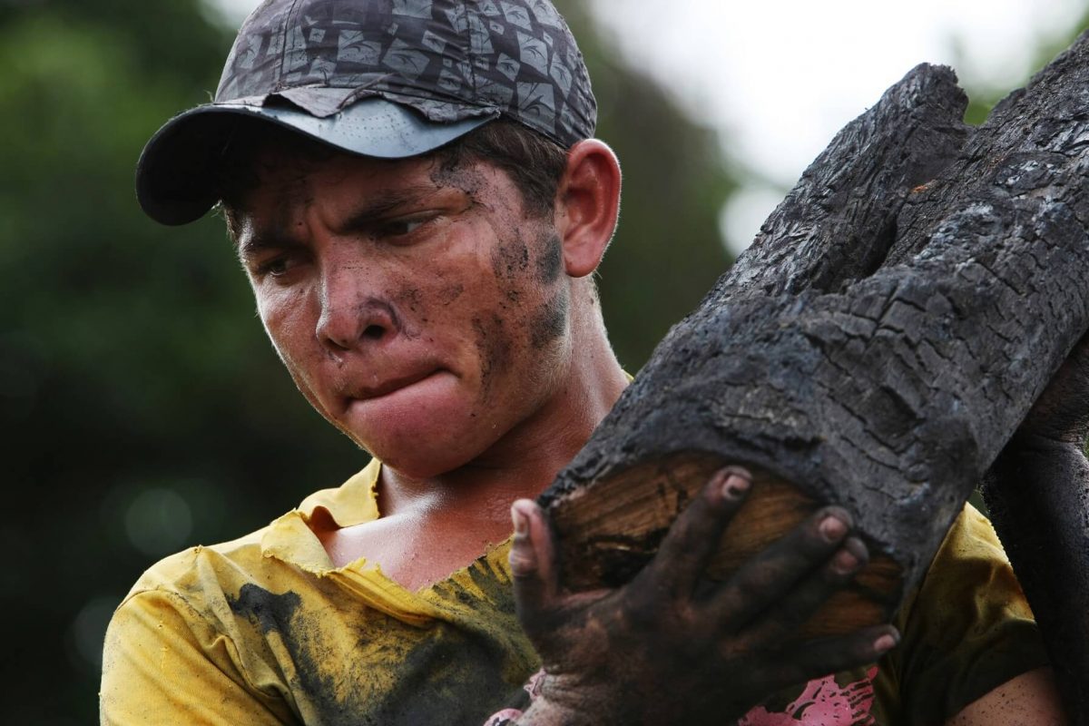 Jovem carvoeiro carrega tronco num dos muitos fornos clandestinos da Região Amazônica. Foto Antonio Scorza