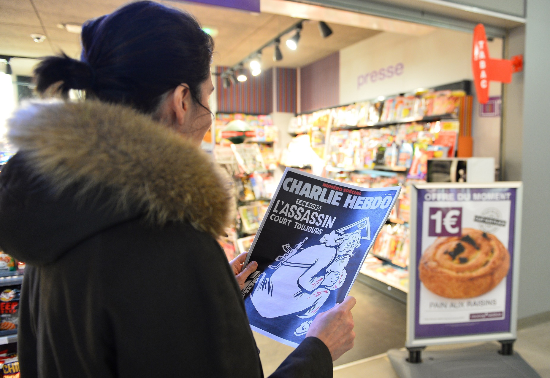 Uma mulher observa a polêmica capa da Charlie Hebdo que lembra o atentado ocorrido no ano anterior