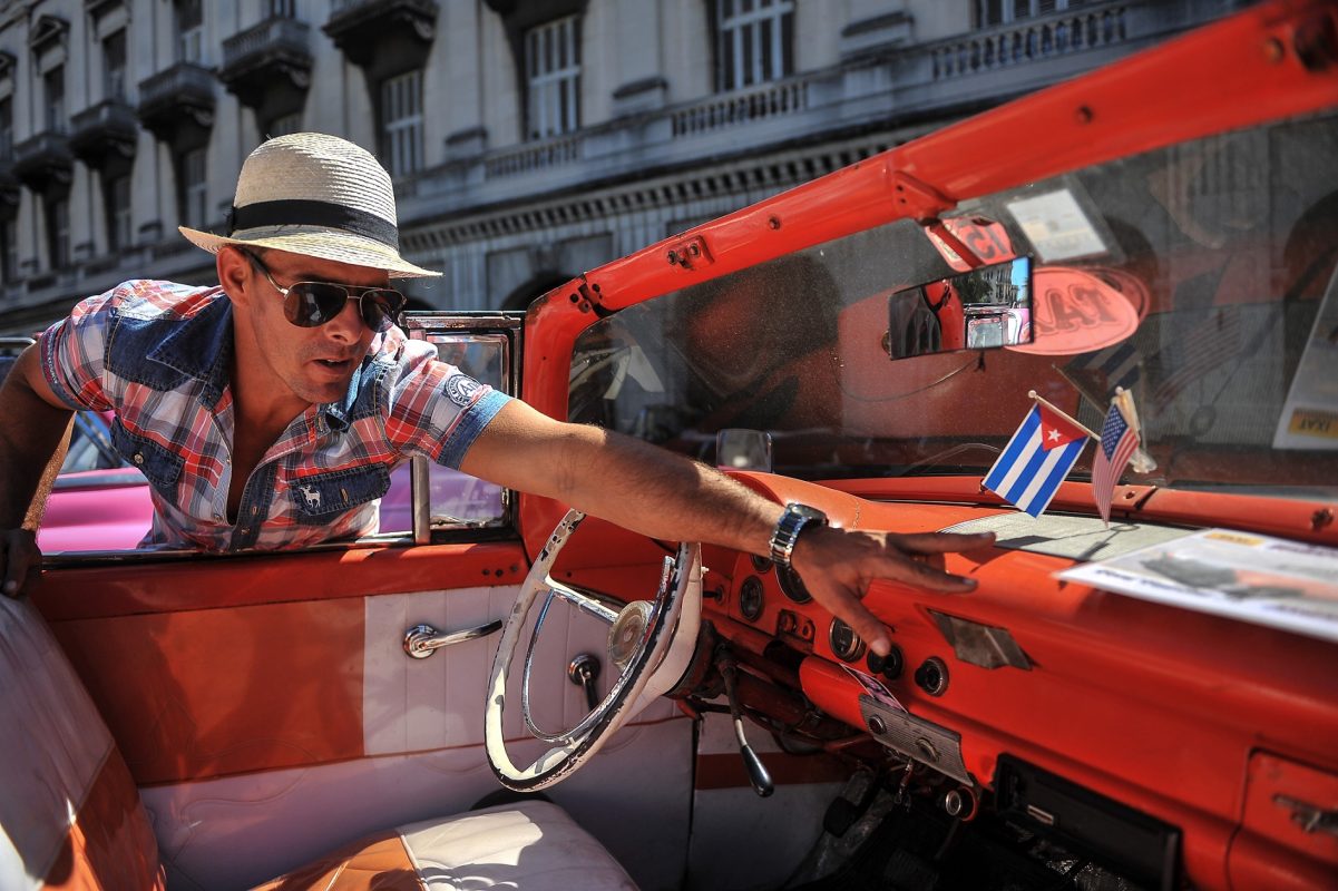 Nas ruas de Havana, um dos tradicionais carros da cidade circula com as bandeiras de Cuba e dos EUA
