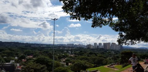 A praça do Pôr do Sol, no Alto de Pinheiros, ocupada com grupos de pessoas sentadas na grama ou em cadeiras de praia