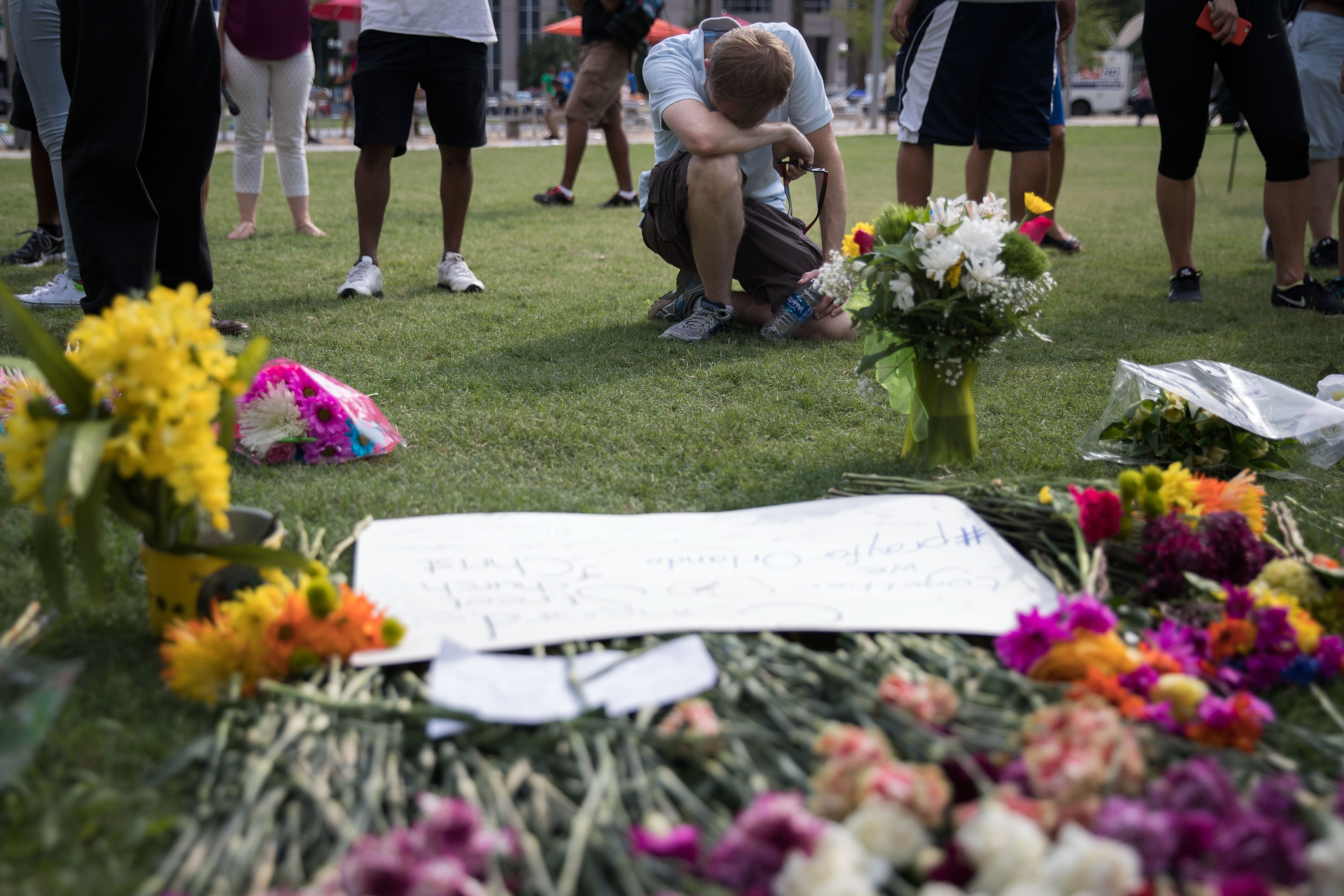 ORLANDO, FL - JUNE 13: Mike Graham of Orlando bows his head at a makeshift memorial prior to an evening vigil for the victims of the Pulse Nightclub shootings, at the Dr. Phillips Center for the Performing Arts, June 13, 2016 in Orlando, Florida. The shooting at Pulse Nightclub, which killed 49 people and injured 53, is the worst mass-shooting event in American history. Drew Angerer/Getty Images/AFP