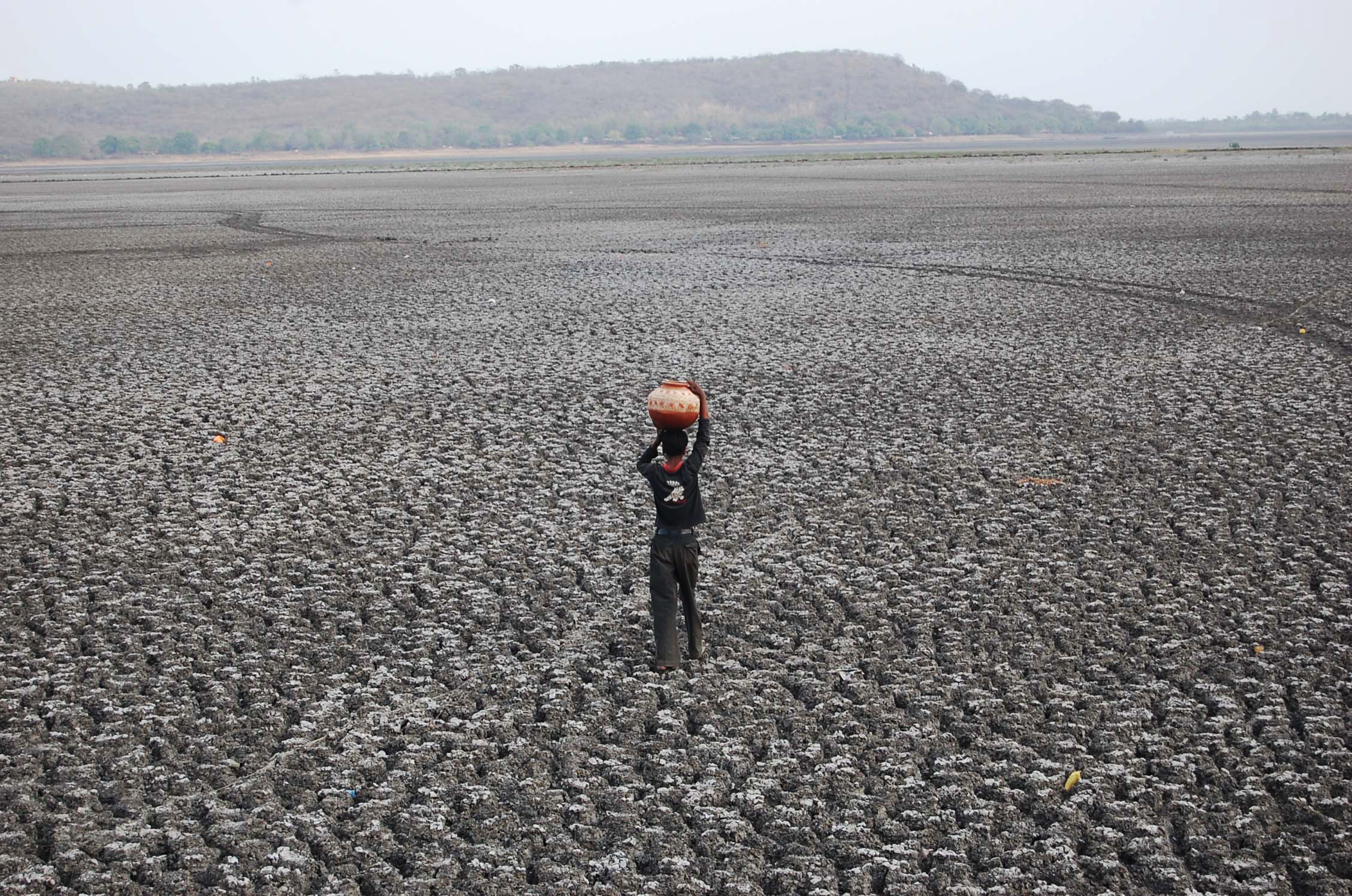 Homem caminha sobre o maior lago artifical da Ásia, o Upper Lake, em Bhopla, na Índia, está seco