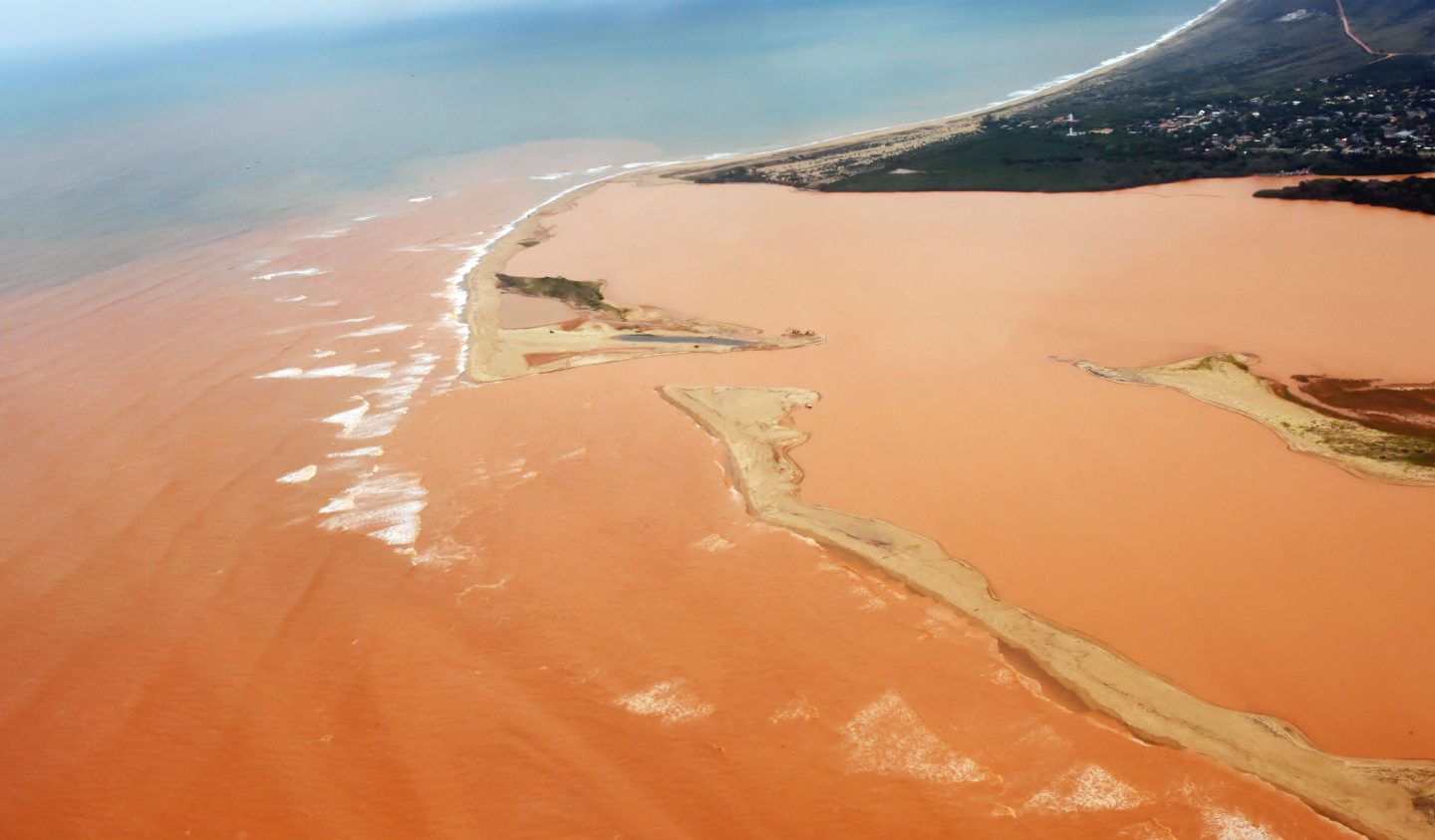 O Rio Doce com as águas vermelhas do minério de ferro já no território do Espírito Santo, em novembro passado (AFP/Estado do Espírito Santo/Fred Loureiro)