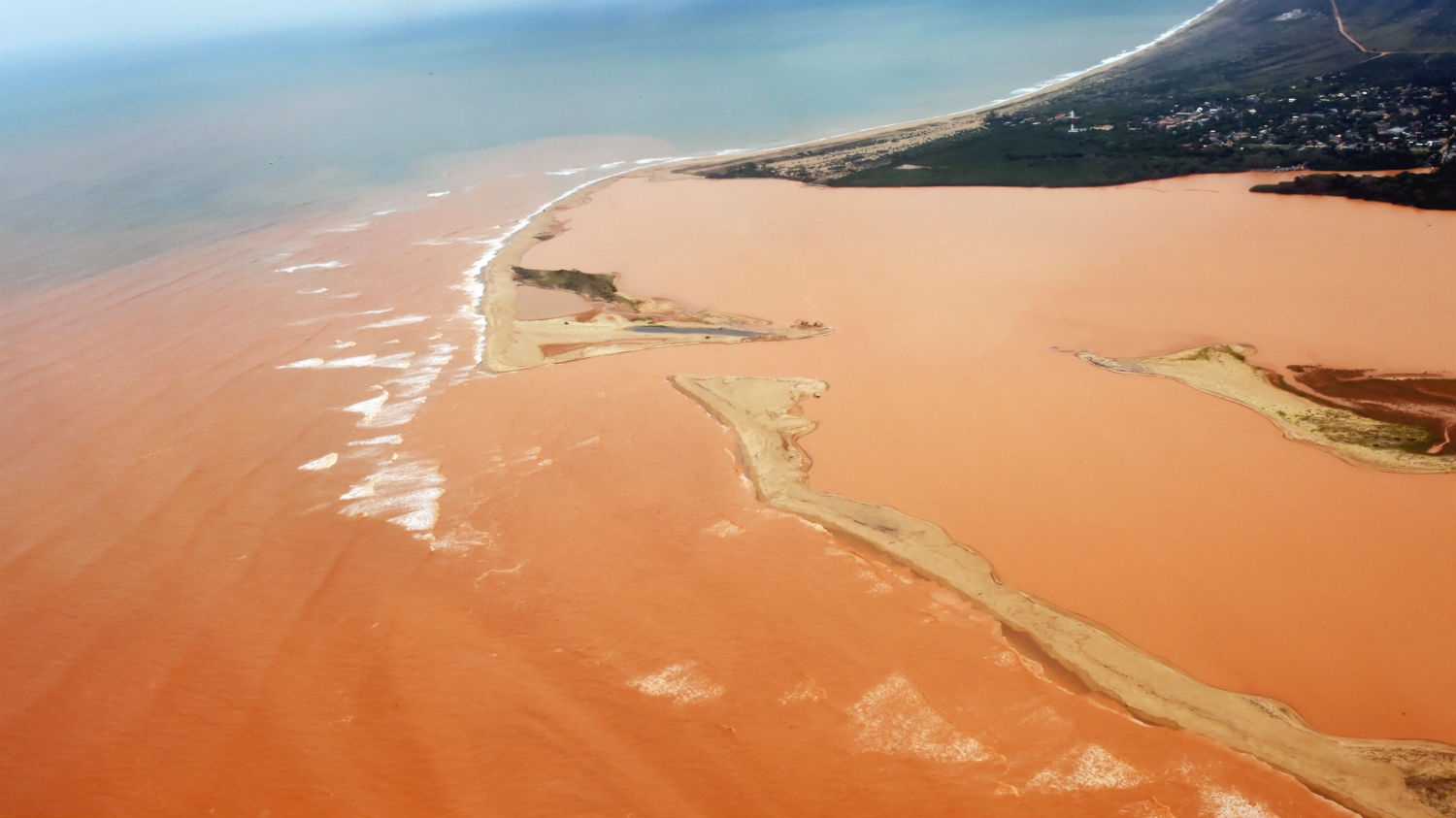  O Rio Doce com as águas vermelhas do minério de ferro já no território do Espírito Santo, em novembro passado (AFP/Estado do Espírito Santo/Fred Loureiro)