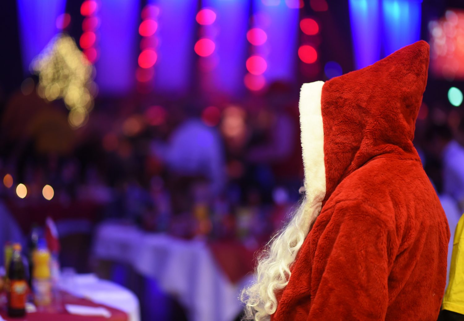 A man dressed as Santa Claus greets guests during a traditional Christmas party for homeless people and others in need at Estrel Hotel in Berlin, Germany, 21 December 2015. Warm clothes, small gifts and a show programme are offered to the guests in addition to roast goose and beer. The event has been held by German singer Frank Zander, the Diakonisches Werk, a charitable organization of Protestant churches, and Estrel Hotel for 20 years. 3000 people attended the party this year. Photo: JENS KALAENE/dpa