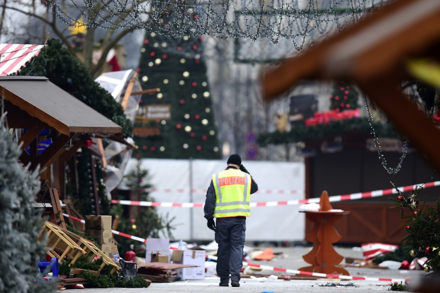 Policial caminha pelo mercado de Natal onde um atentado deixou 12 mortos e 48 feridos. Foto de Tobias Schwarz/AFP