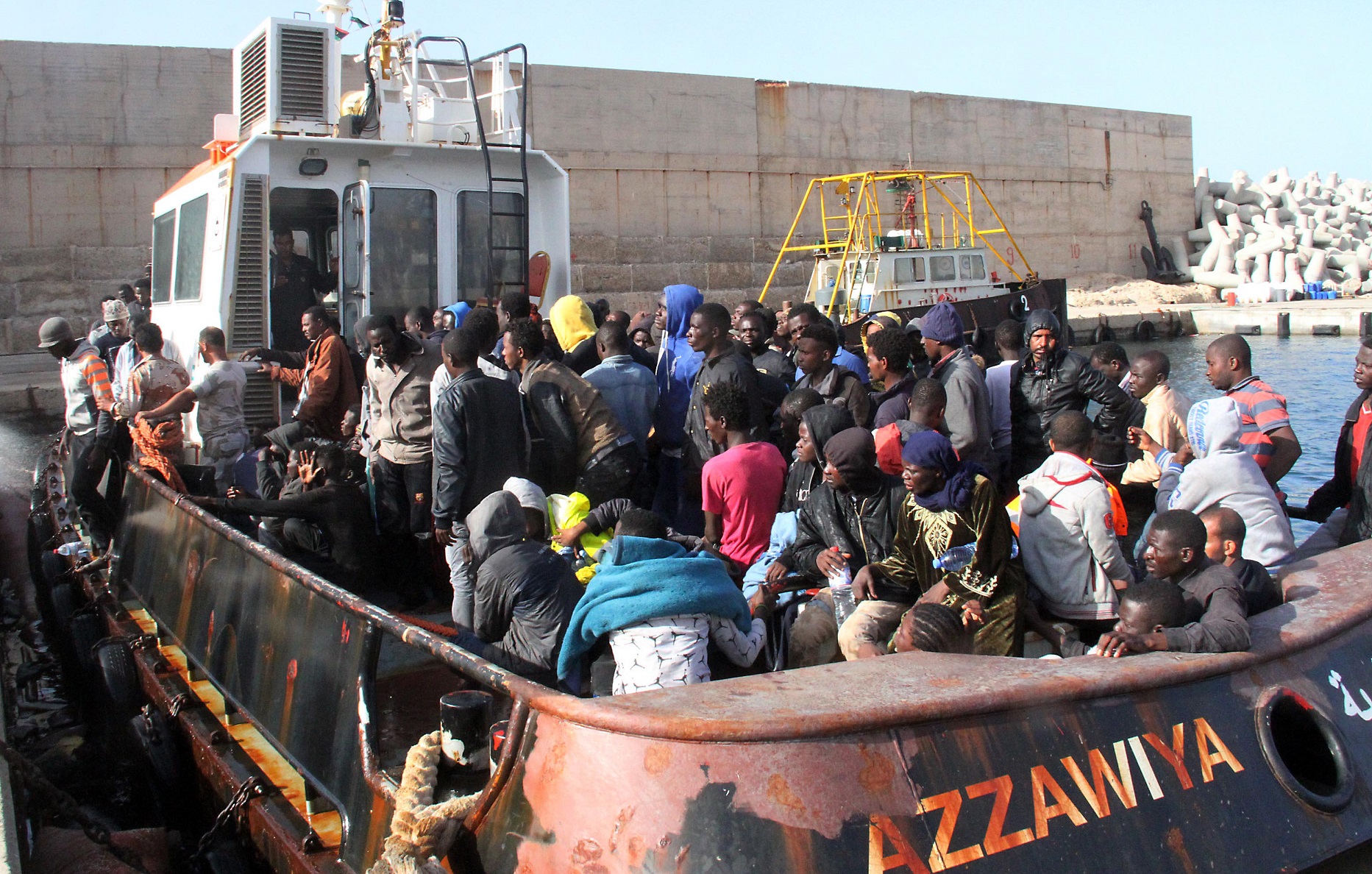 Migrantes ilegais chegam ao porto de Zawiyah, na Lybia, após serem capturados a caminho da Europa. Foto Mahmud Turkia/AFP