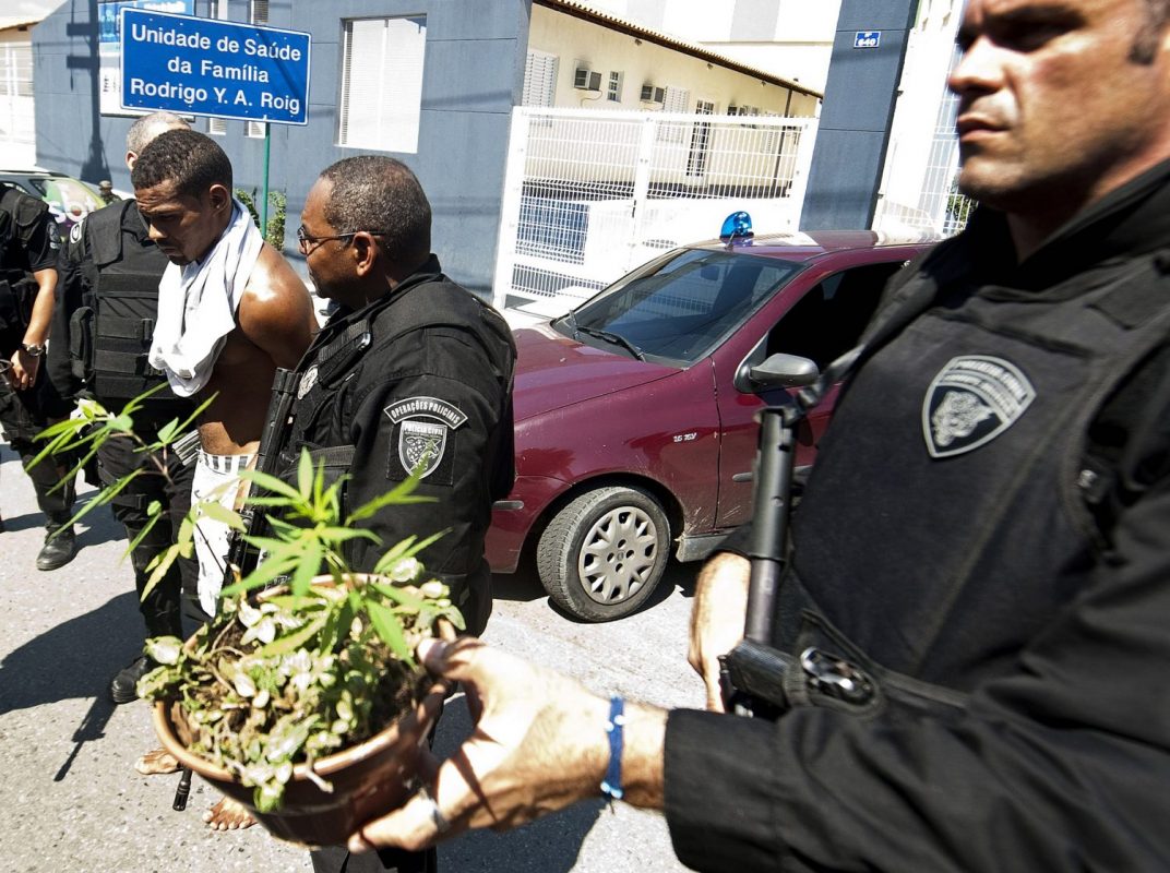 Policiais apreendem um vaso de maconha no morro do Alemão. Foto Antonio Scorza/AFP