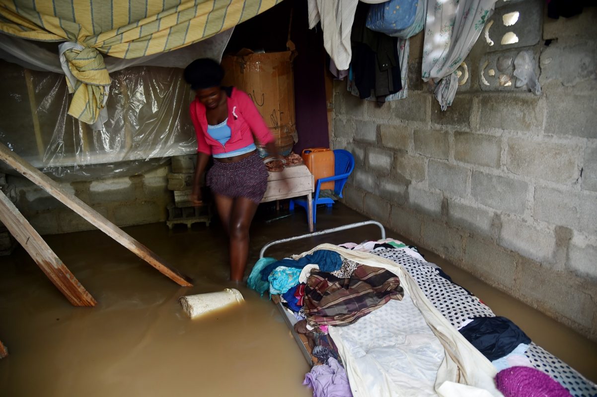 Marie Charlotte caminha dentro da sua casa, no Haiti, inundada pelo furacão Irma. Foto Hector Retamal/AFP