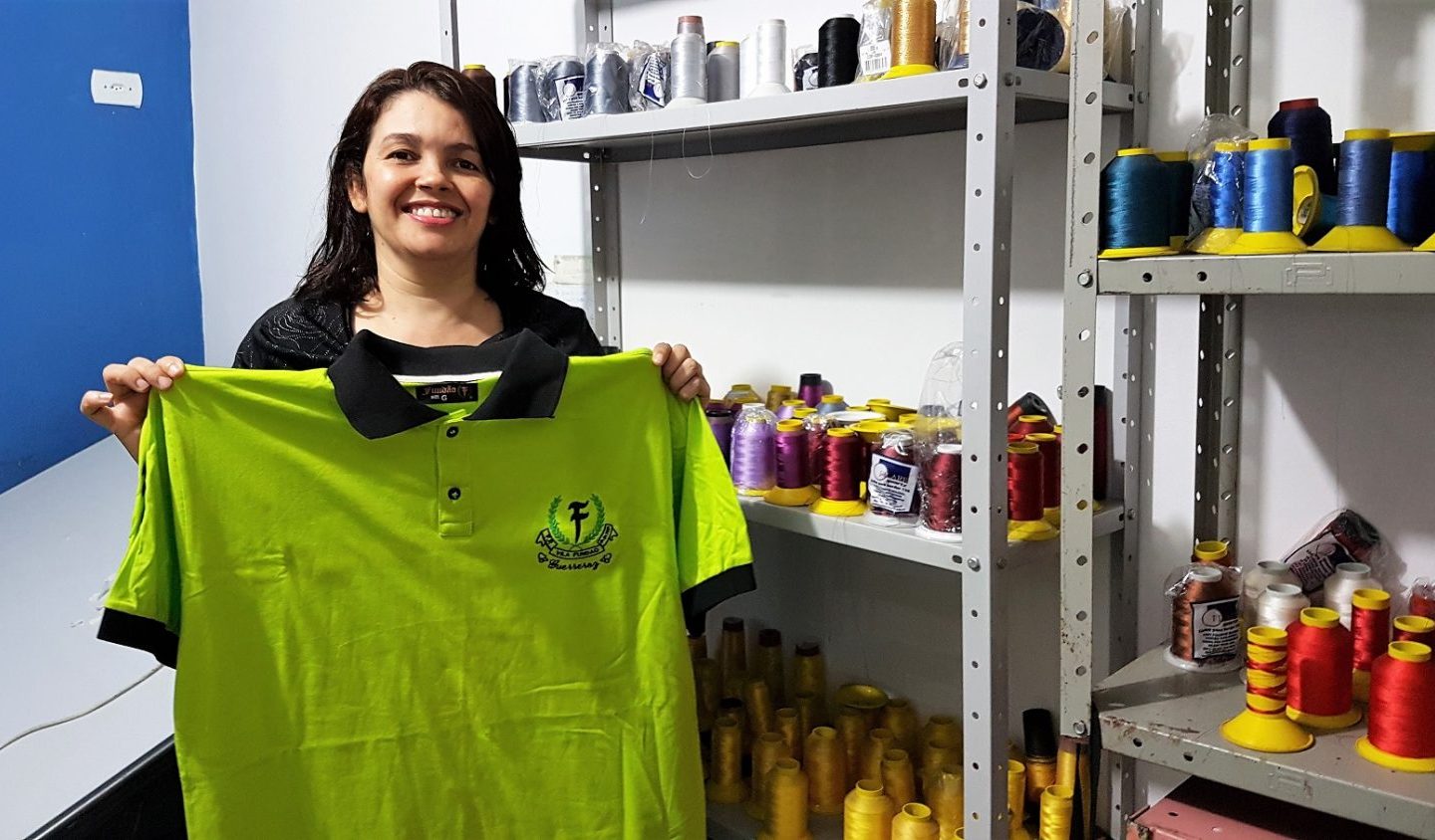 Maria da Consolação exibe, feliz, uma das camisas produzidas para as grifes do Capão Redondo. Foto Florência Costa