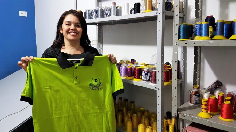 Maria da Consolação exibe, feliz, uma das camisas produzidas para as grifes do Capão Redondo. Foto Florência Costa