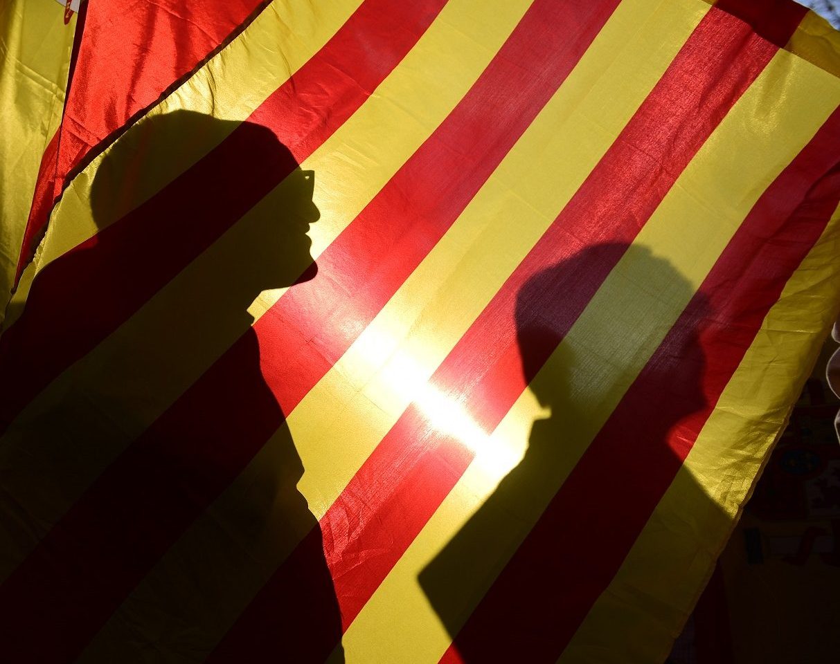 A sombra dos manifestantes na bandeira da conturbada Catalunha. Foto Pierre-Philippe Marcou/AFP