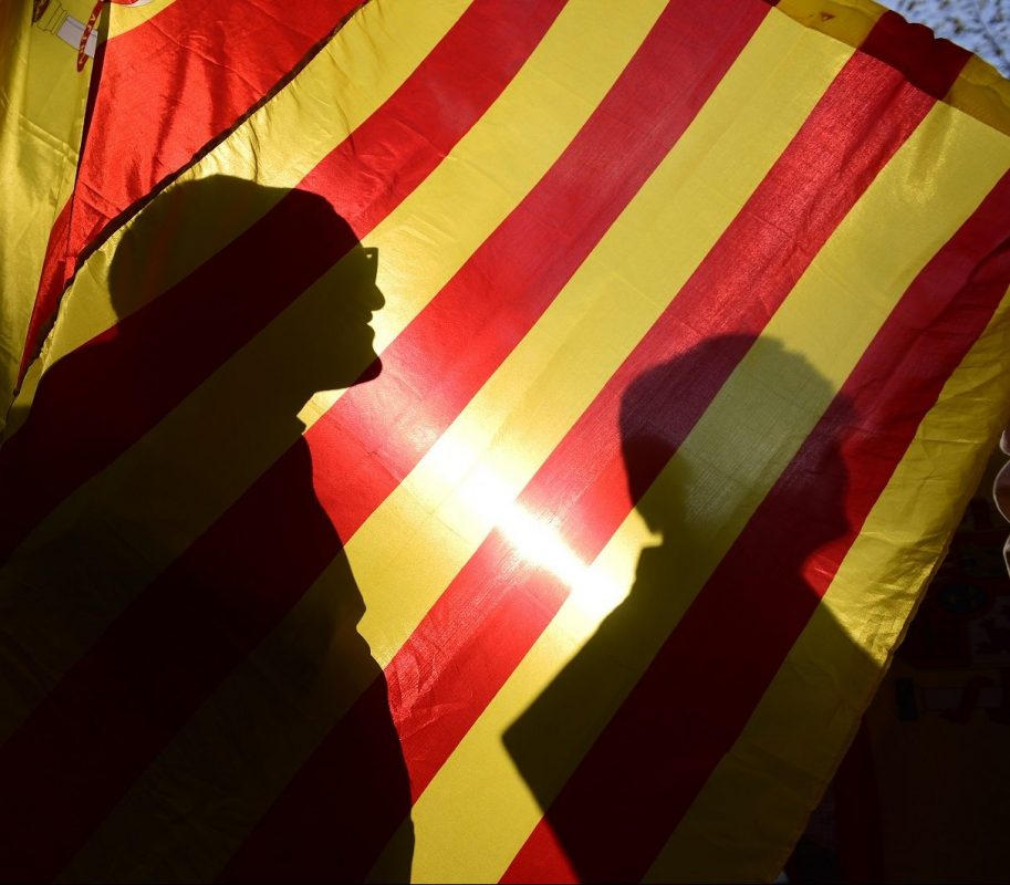 A sombra dos manifestantes na bandeira da conturbada Catalunha. Foto Pierre-Philippe Marcou/AFP