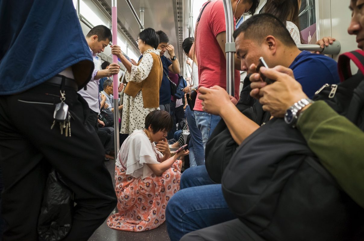 Chineses no metrô de Pequim com os seus smartphones. Foto an weijun / Imaginechina