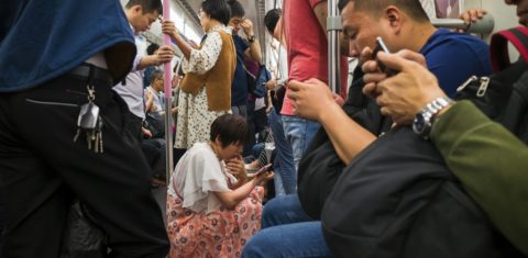 Chineses no metrô de Pequim com os seus smartphones. Foto an weijun / Imaginechina