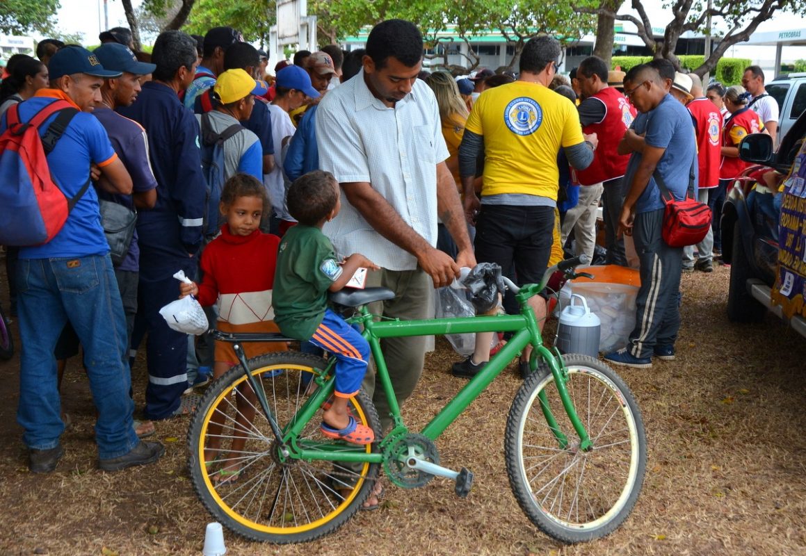 Luiz Mota, 33 anos, garantiu um litro de leite e pães para os dois filhos. Ele carrega as crianças numa bicicleta emprestada. Foto Charles Wellington