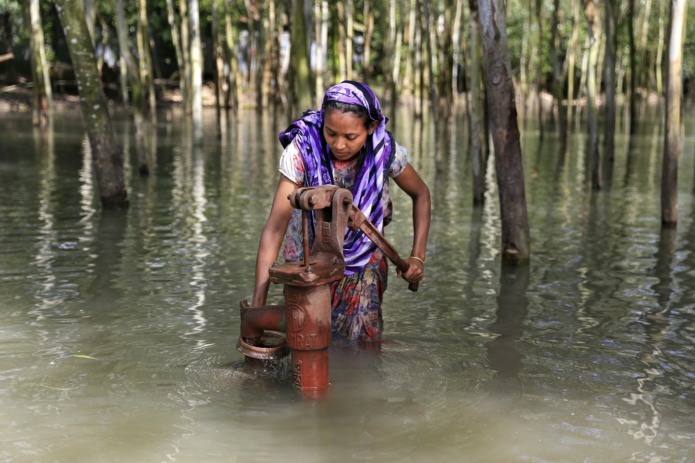 Em Bangladesh, a jovem Salma coleta água para abastecer a família. As doenças de veiculação hídrica estão entre as principais causas de mortalidade infantil. Foto Mushfiqul Alam/NurPhoto