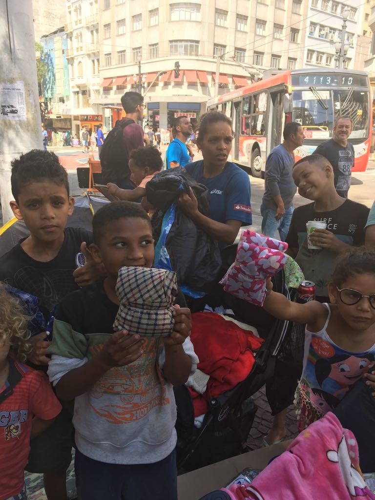 Crianças recebem os sacos de dormir feitos com os tecidos dos guarda-chuvas. Foto Divulgação