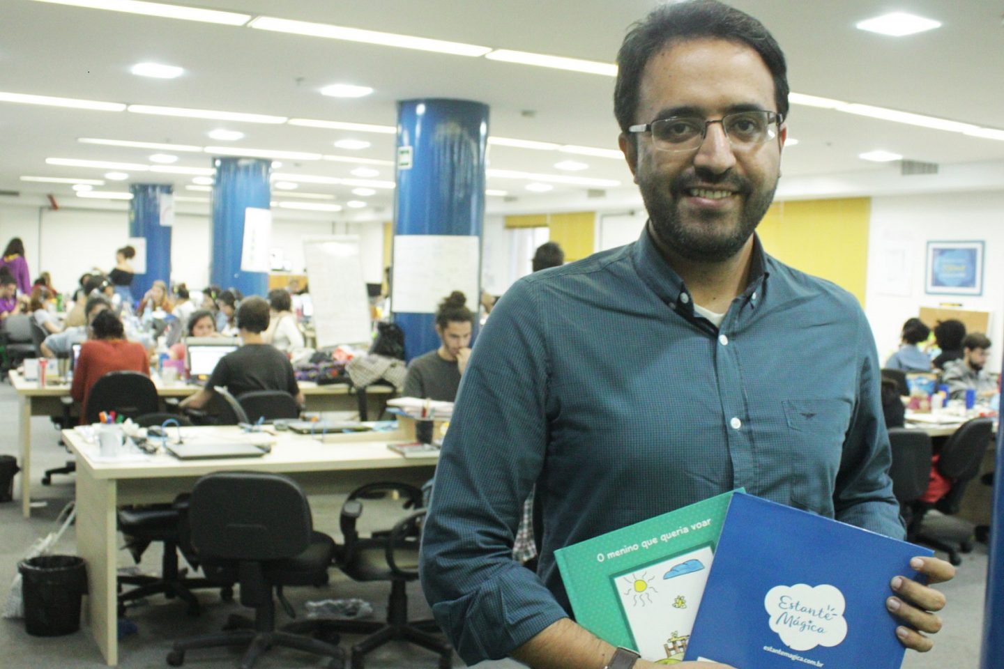 Robson Lemos posa com alguns dos livros produzidos pela Estante Mágica (Foto: Christina Martins)