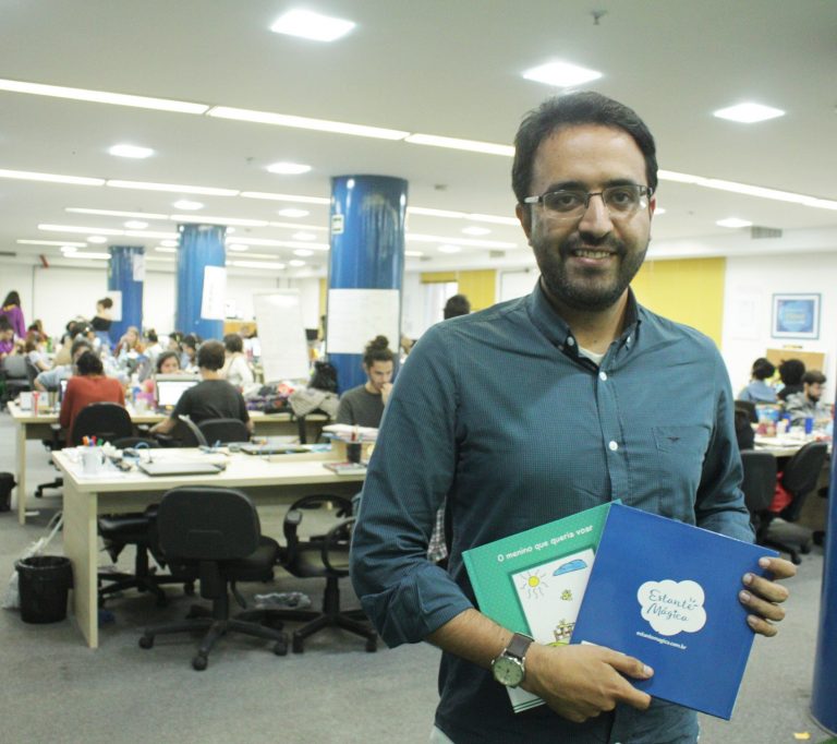Robson Lemos posa com alguns dos livros produzidos pela Estante Mágica (Foto: Christina Martins)