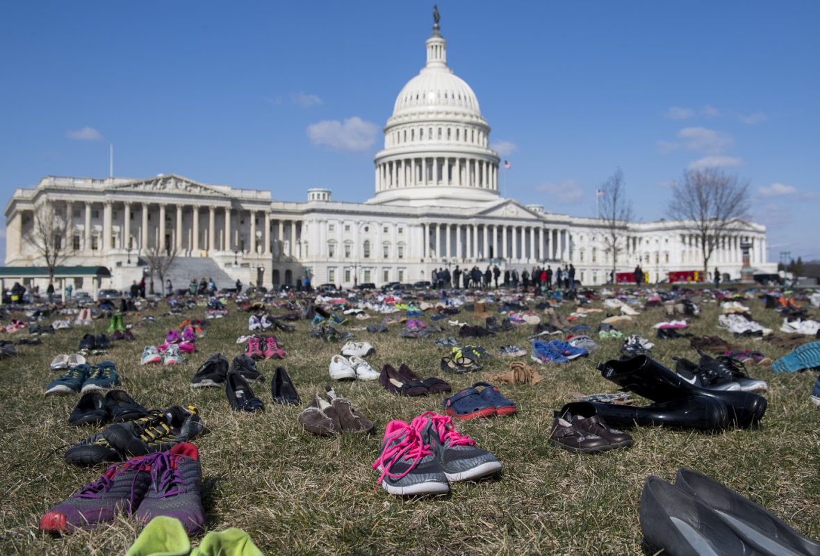 Em um protesto em frente ao Capitólio, em Washington, sete mil pares de calçados lembram as crianças mortas por arma de fogo no país. Foto Saul Loeb/AFP