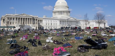 Em um protesto em frente ao Capitólio, em Washington, sete mil pares de calçados lembram as crianças mortas por arma de fogo no país. Foto Saul Loeb/AFP