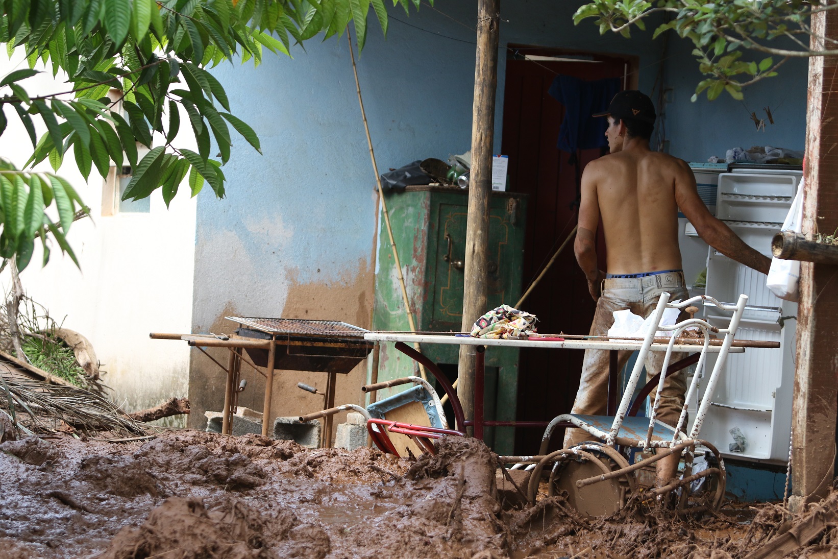 Uma das vítimas do desastre tenta salvar uma geladeira no meio dos escombros. Foto Doug Patrício/DPA