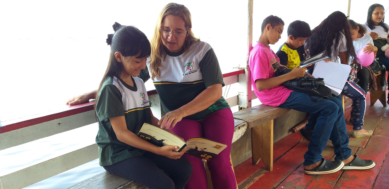 Joristelma Queiroz, gestora da escola, ajuda Jeizy Kerle, de 9 anos, a ler a história dos Sete Camundongos Cegos. Foto Adauto Silva (Seduc)