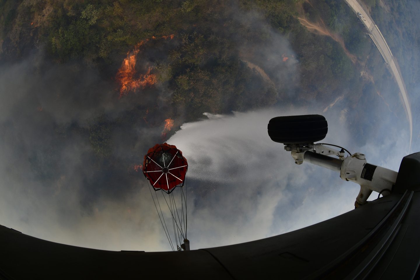 Helicóptero militar despeja água de bolsa para tentar apagar queimadas na região de Roboré. na Bolívia (Foto: Carlos Orias B)