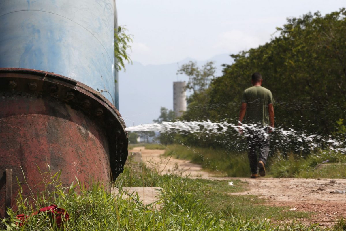Água vaza de tubulação da Cedae: estatal admite que não combate desperdício em áreas dominadas por tráfico ou milícia (Foto: Custódio Coimbra)