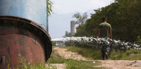 Água vaza de tubulação da Cedae: estatal admite que não combate desperdício em áreas dominadas por tráfico ou milícia (Foto: Custódio Coimbra)