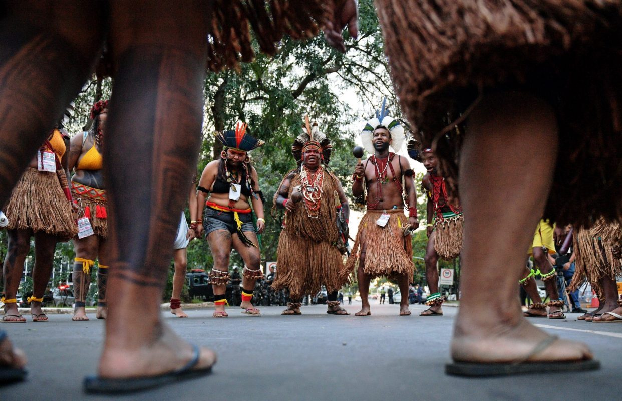 Brazilian indigenous men perform a ritual dance during a protest against the government's decision not to recognize the land demarcation of indigenous people living in Raposa Serra do Sol, Roraima State, in Brasilia, on April 25, 2018. - About 2,500 indigenous people from different tribes are taking part in the Indigenous National Mobilization (MNI) week - a mobilization which seeks to tackle territorial rights' negotiations with the government. (Photo by CARL DE SOUZA / AFP)