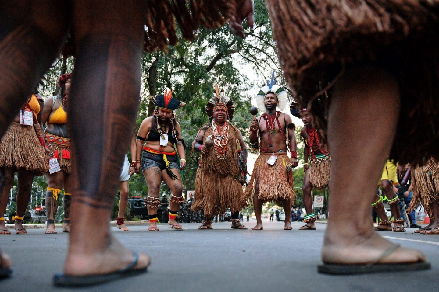 Brazilian indigenous men perform a ritual dance during a protest against the government's decision not to recognize the land demarcation of indigenous people living in Raposa Serra do Sol, Roraima State, in Brasilia, on April 25, 2018. - About 2,500 indigenous people from different tribes are taking part in the Indigenous National Mobilization (MNI) week - a mobilization which seeks to tackle territorial rights' negotiations with the government. (Photo by CARL DE SOUZA / AFP)