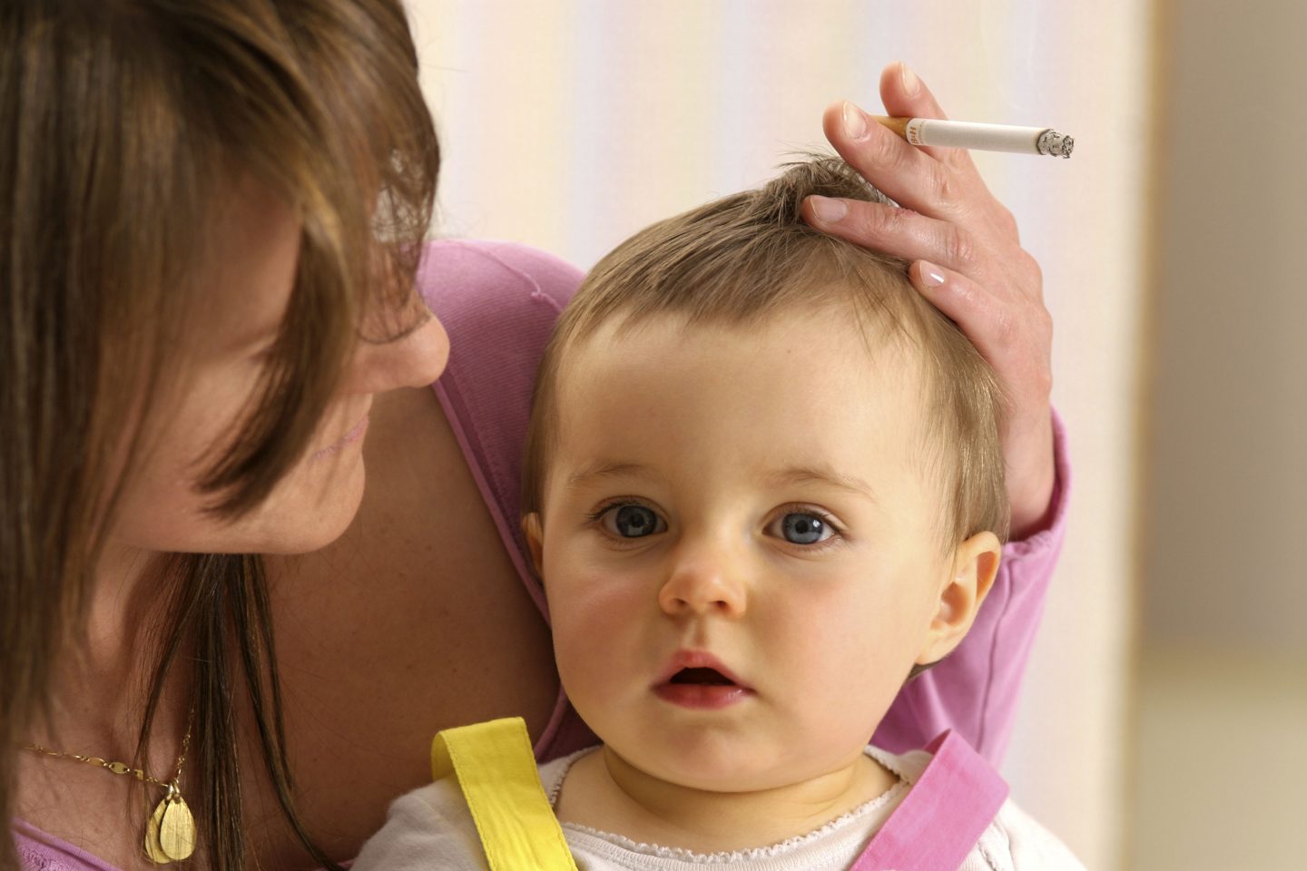 Mãe fumando com bebê no colo: pesquisa indica que tabagismo materno leva à obesidade do filho quando adulto (Foto: MAY/BSIP/AFP)
