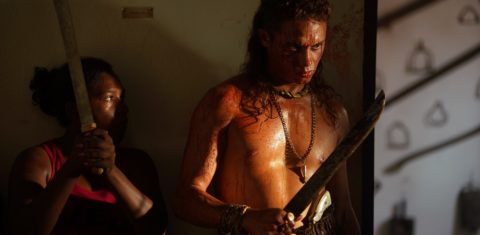 O fora da lei Lunga (Silvero Pereira) comanda, de dentro do museu, a resistência dos moradores de Bacurau, que usam as armas em exposição para mandar bala nos invasores (Foto: Victor Jucá/Divulgação)