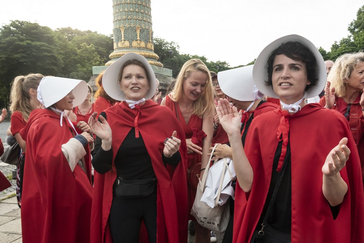 Ativistas se vestem como as personagens de "The Handmaid's Tale" para protestar contra a proibição do aborto em frente à Embaixada dos EUA em Paris. Foto Samuel Boivin/NurPhoto