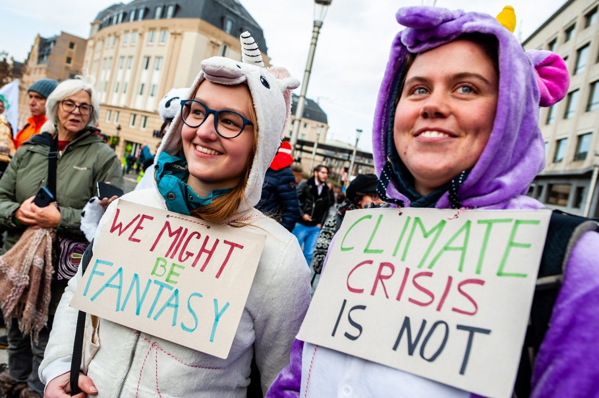 Em Bruxelas, duas manifestantes tentam explicar que a crise climática não é uma fantasia. Foto Arroyo Fernandez/NurPhoto