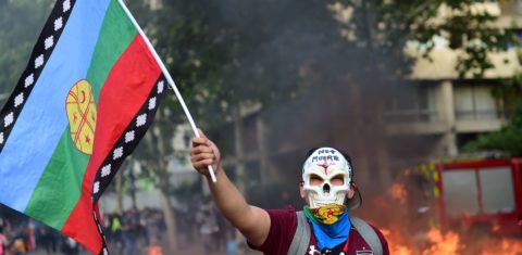 Manifestante, com uma bandeira do povo indígena Mapuche, protesta contra a política econômica do governo chileno. Foto Martin Bernetti/AFP