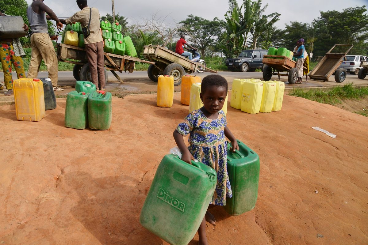 Menina carrega dois galões de água na região de Abobo, em Abidjan, na Costa do Marfim. Os países da África estão entre os que mais sofrem com a escassez de água. Foto Issouf Sanogo/AFP