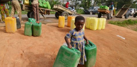 Menina carrega dois galões de água na região de Abobo, em Abidjan, na Costa do Marfim. Os países da África estão entre os que mais sofrem com a escassez de água. Foto Issouf Sanogo/AFP