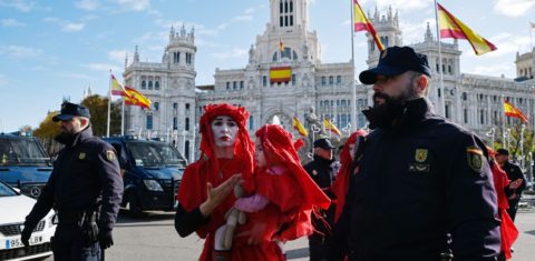 Police officers walk beside global environmental movement Extinction Rebellion activists during a protest at the Cibeles square in Madrid, on December 3, 2019. - Spain's Socialist government offered to host this year's UN climate conference, known as COP25, from December 2 to December 13, 2019, after the event's original host Chile withdrew last month due to deadly riots over economic inequality. (Photo by OSCAR DEL POZO / AFP)