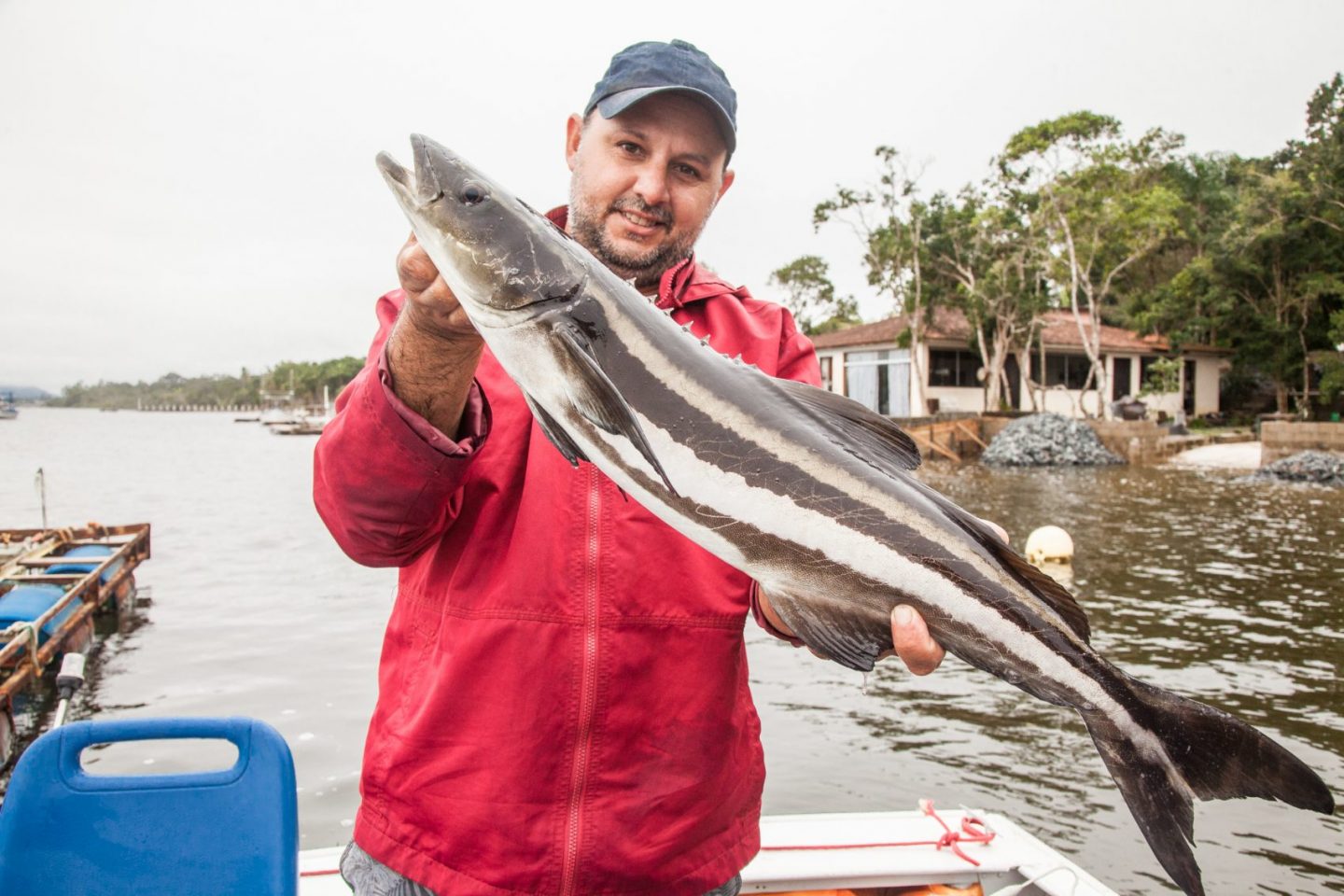 O biólogo marinho Arthur Artemtchonque e um beijupirá: espécie cada vez mais valorizada pela gastronomia, é cultivada em um grande tanque diante de sua casa até chegar a 5 quilos (Foto: Caio Ferrari)
