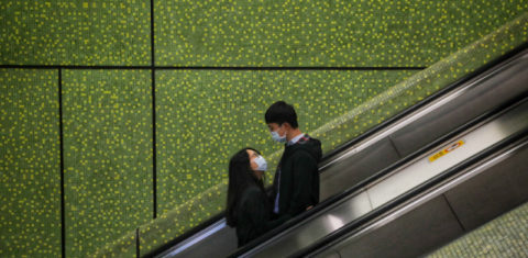 Jovem casal em escada rolante em Hong King: amor em tempos de pandemia (Vivek Prakash / AFP)