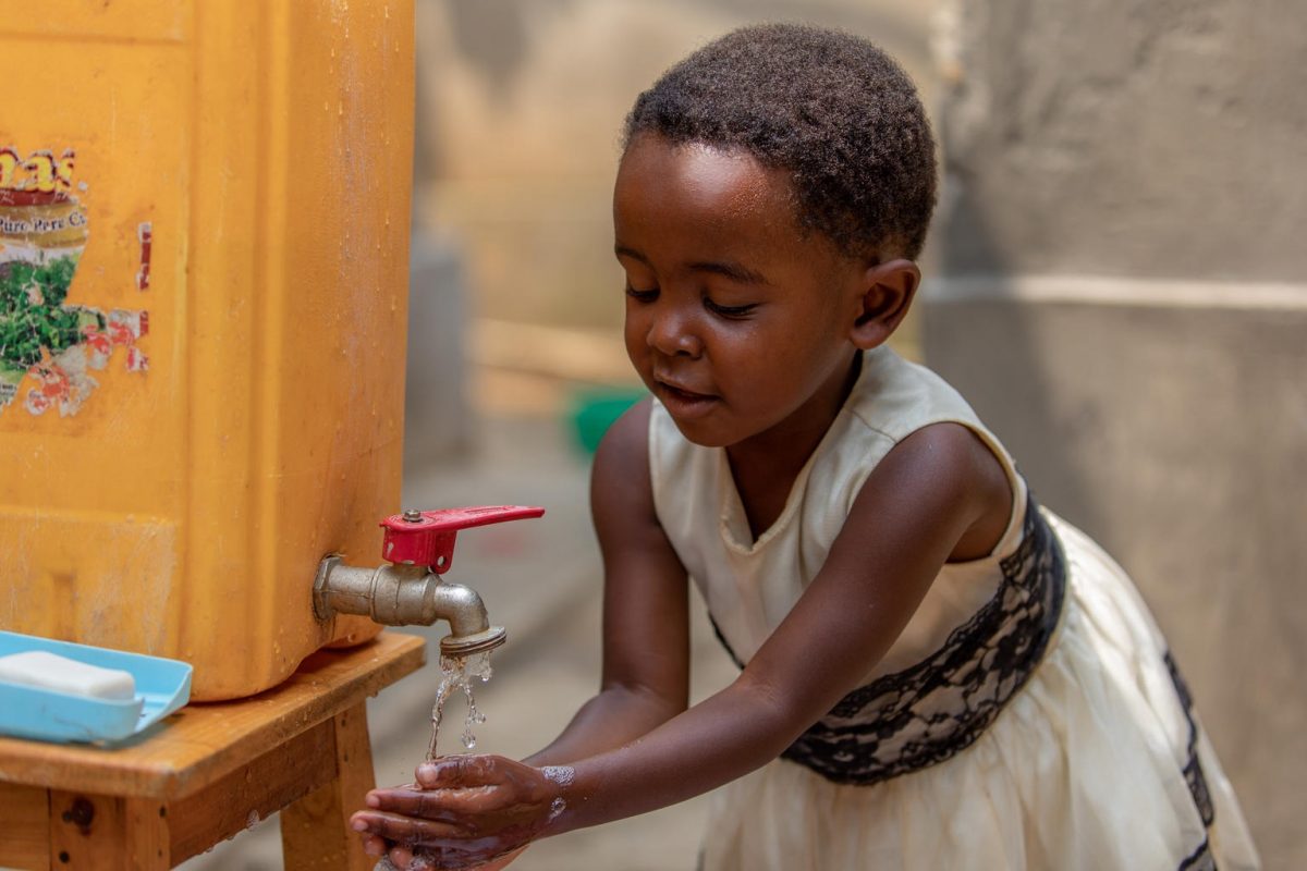A pequena Shania, de 4 anos, lavas as mãos em uma torneira improvisada, num subúrbio de Kigali, capital da Rwanda. Foto Unicef/2020