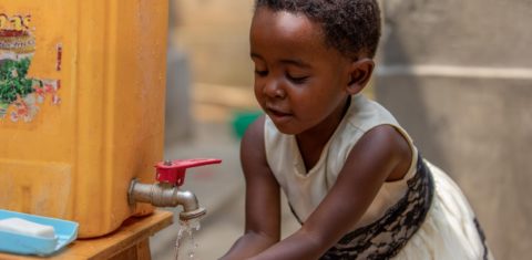 A pequena Shania, de 4 anos, lavas as mãos em uma torneira improvisada, num subúrbio de Kigali, capital da Rwanda. Foto Unicef/2020