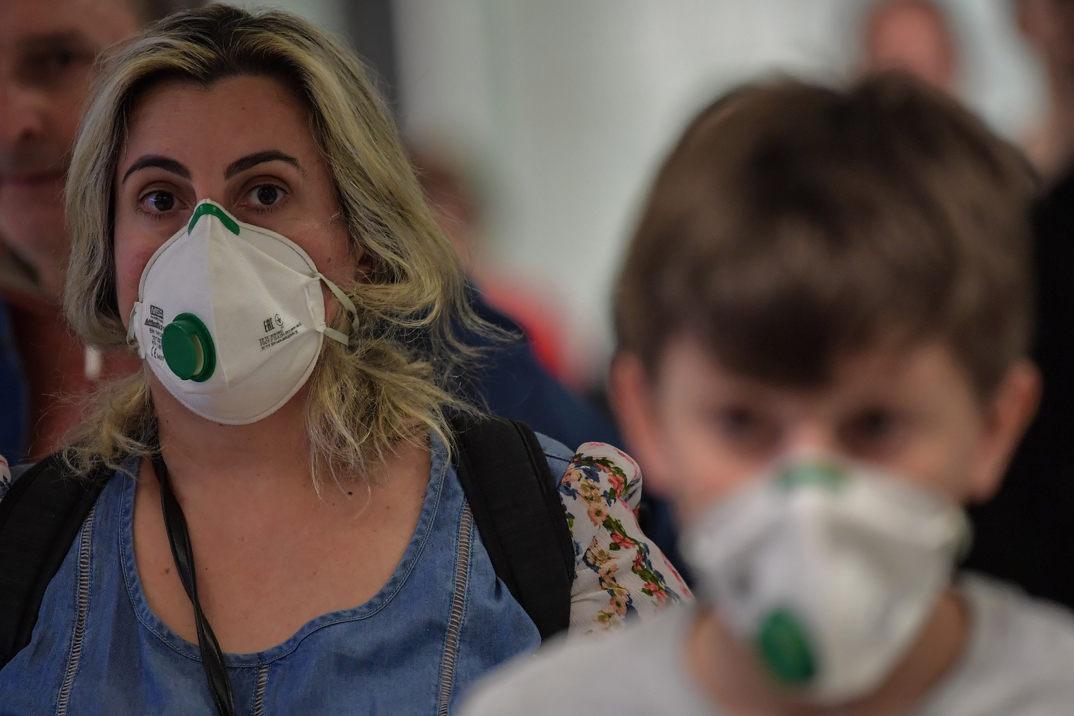 Passageiros vindo da Itália desembarcam no aeroporto de Guarulhos, em São Paulo, usando máscaras. Foto Nelson ALMEIDA / AFP)